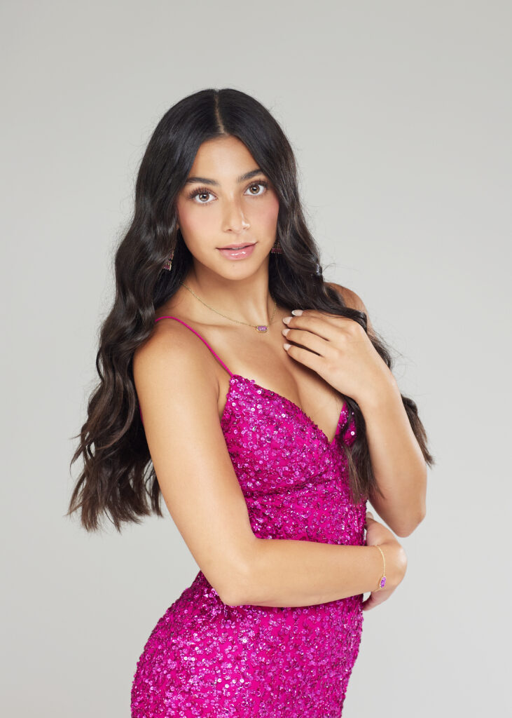 Senior Girl with medium to olive skin posed in pink homecoming/prom dress