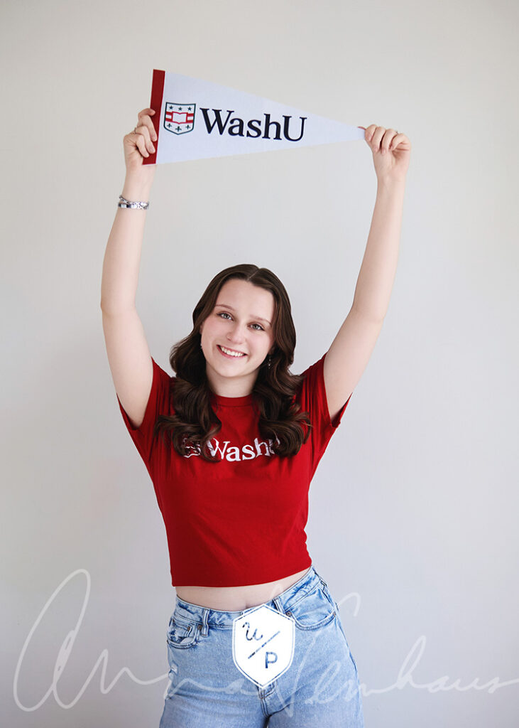 brunette senior girl holding a WashU pennant