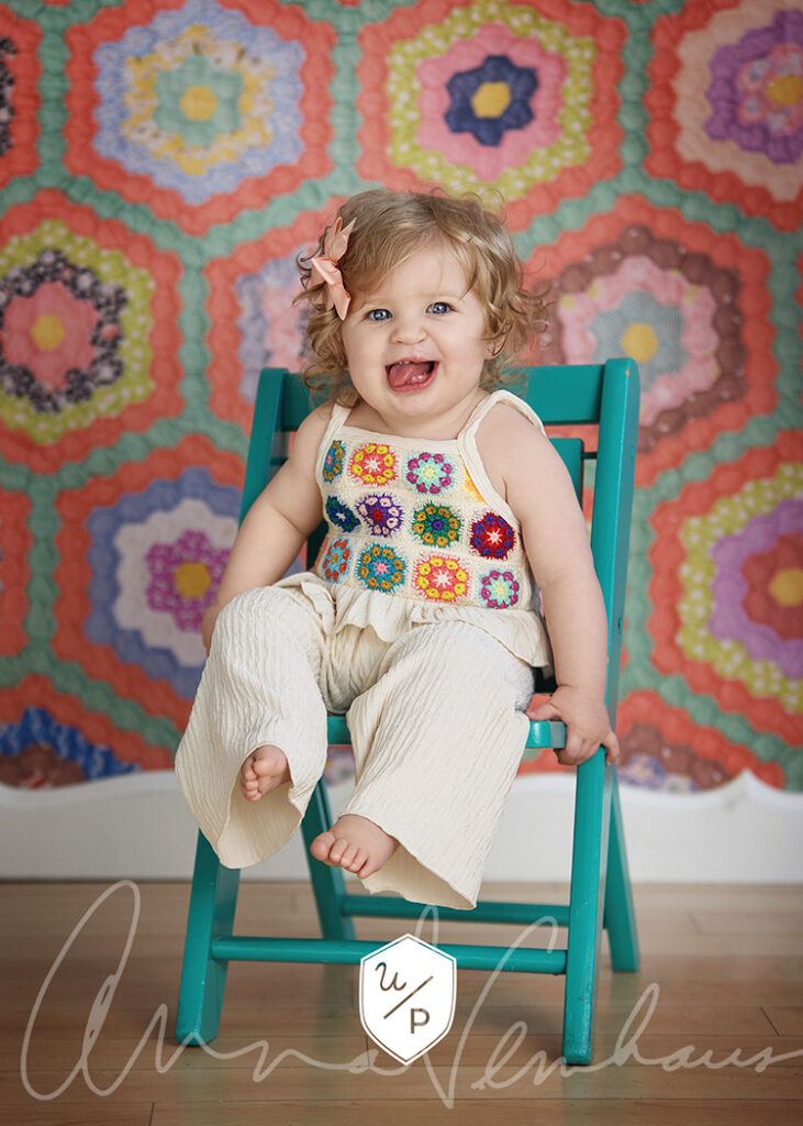 little girl in crochet top in a teal chair
