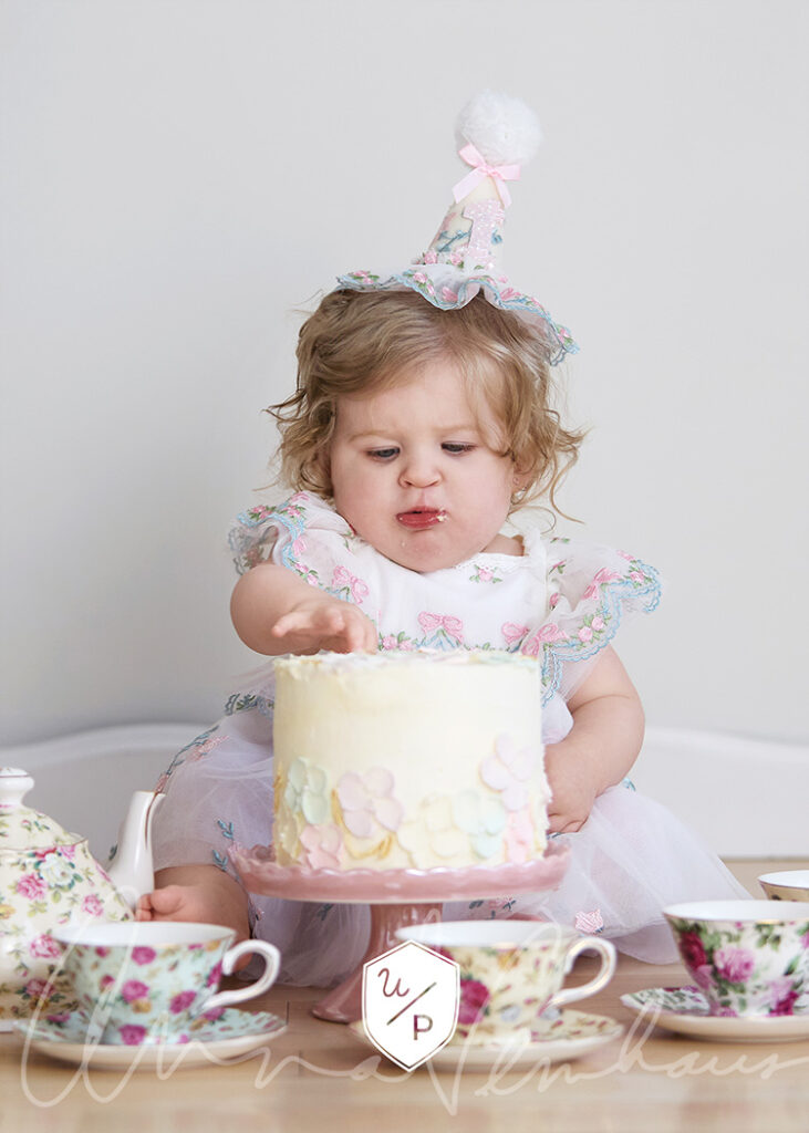 little girl sitting behind a cake