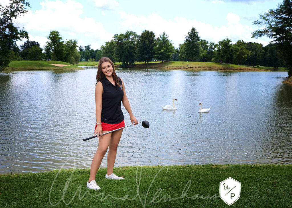 senior girl golfer posed on the green with swans